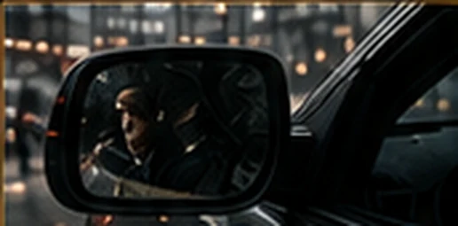 Side mirror reflecting a figure following a vehicle on a wet street