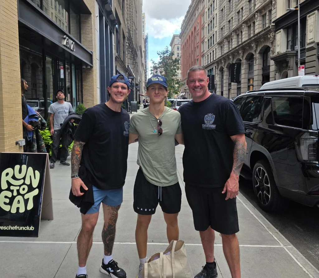 James Gonzales and a Shadow Securities protection agent with Jack and the Yes Chef team on a Lower Manhattan sidewalk beside a black SUV and a Yes Chef Run Club sign.