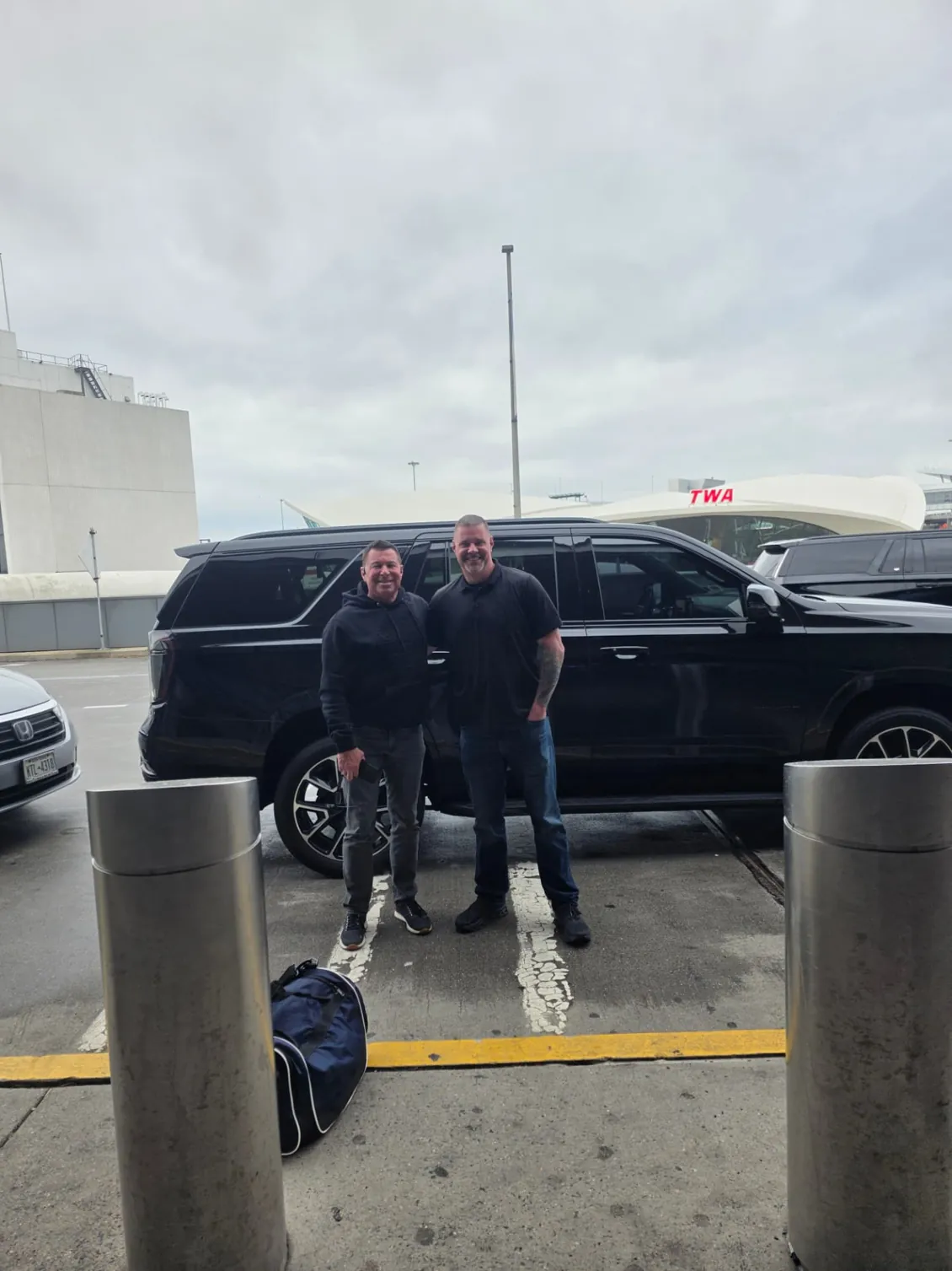 Two Shadow Securities protection agents beside a black SUV at the TWA Flight Center terminal at JFK International Airport in Queens, New York.