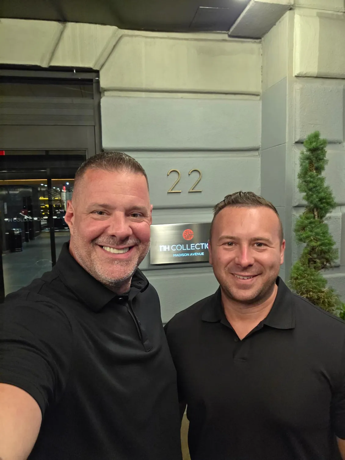 Two protection agents at a Madison Avenue hotel entrance in the evening