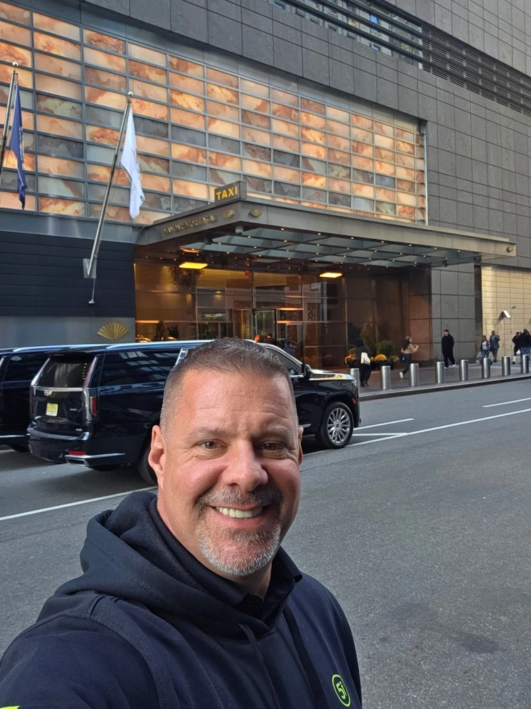 James Gonzales wearing a hoodie near a New York hotel taxi canopy during a visiting-team assist